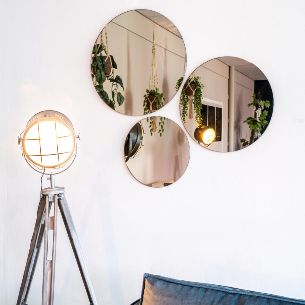 Ronde wandspiegels in verschillende maten aan de muur geplakt