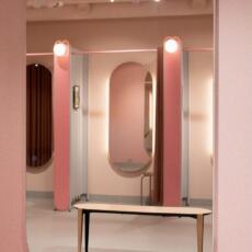 Dubbele toogspiegel, hangend aan de muur in een paskamer