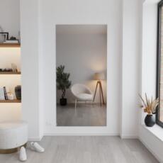 Hoge spiegel gemonteerd in een lichte woonkamer