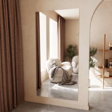 Smalle spiegel gemonteerd op een beige muur