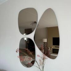 Organische spiegel brons gekleurd in de woonkamer aan de muur