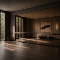Dansstudio met bronzen spiegelwand, balletbarre en warme hotel-chique sfeer.