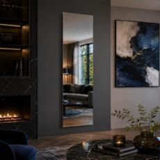 Hoge rechthoekige spiegel in een luxe woonkamer met donkere accenten en haard.