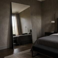 Grote staande spiegel tegen de muur in een hotel chique slaapkamer.