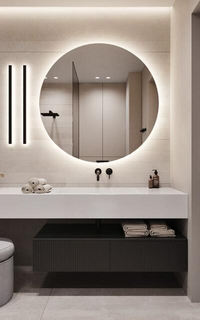 Rond verzilverde spiegel met verlichting in een badkamer