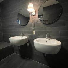 Twee ronde spiegels in een badkamer met lijst