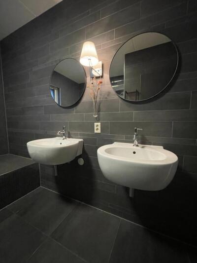 Twee ronde spiegels in een badkamer met lijst