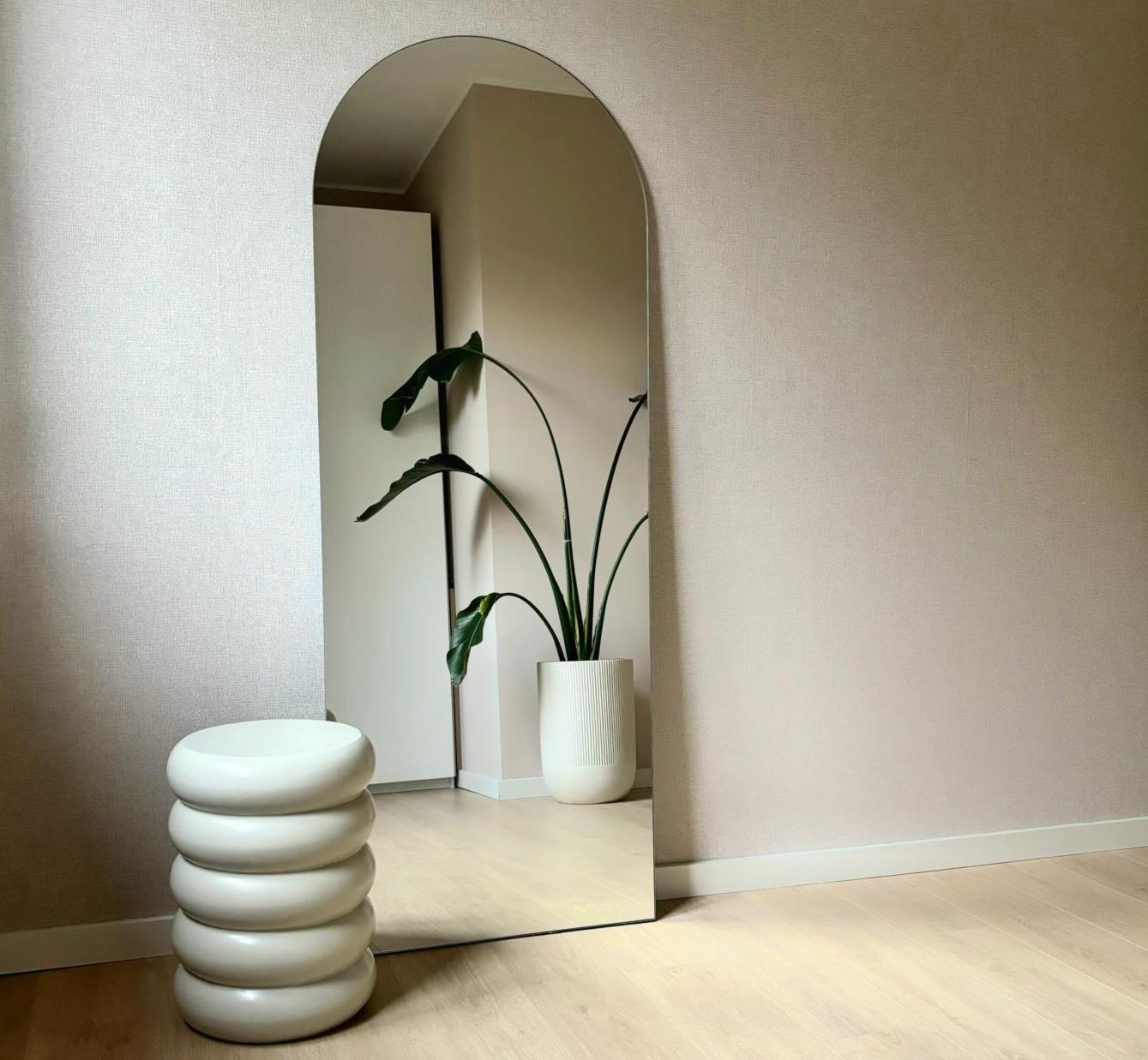 Een lange slaapkamerspiegel in een boogvorm