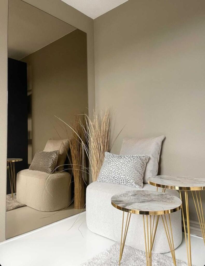 Grote bronzen wandspiegel aan de muur geplakt