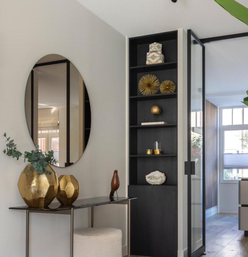 Ronde gekleurde spiegel in een woonkamer aan de muur geplakt