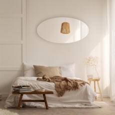 Ovale spiegel hangend in de slaapkamer